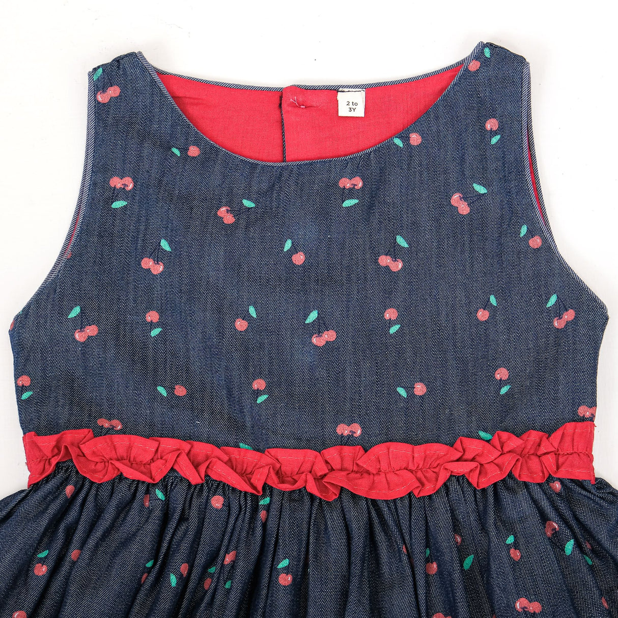Close-up front bodice view of cherry print denim dress for girls