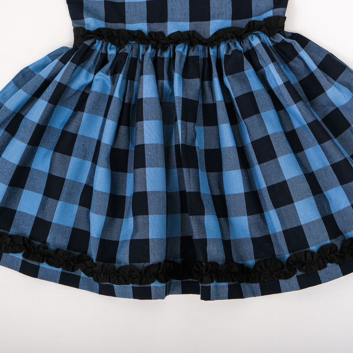 Close-up of gathered skirt with ruffle details on waist and hemline