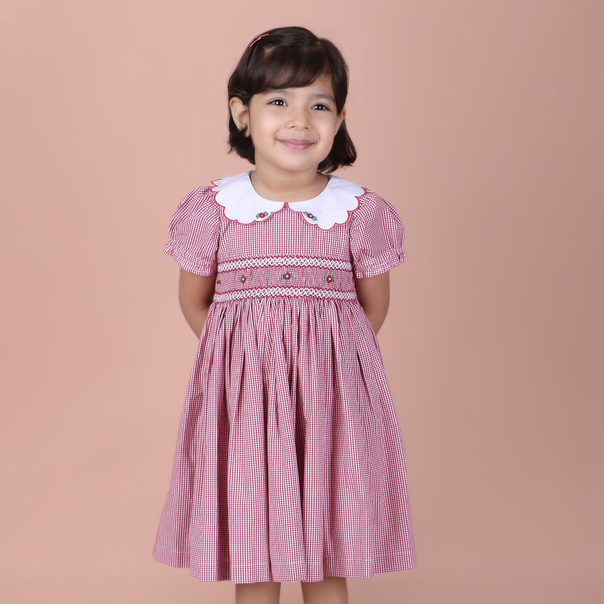 girl wearing red micro gingham dress with smocking