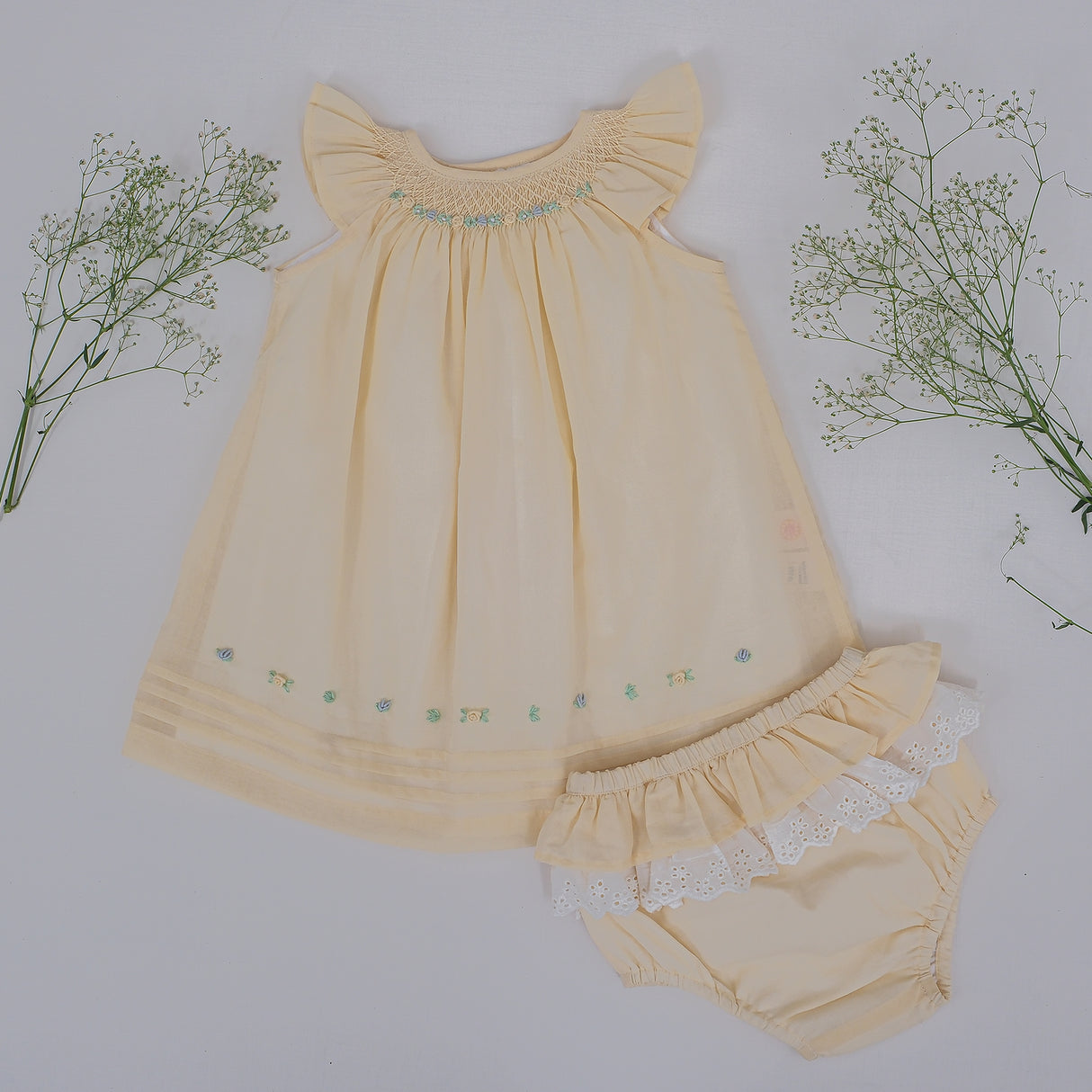Front flat lay view of yellow hand smocked baby dress with matching bloomers