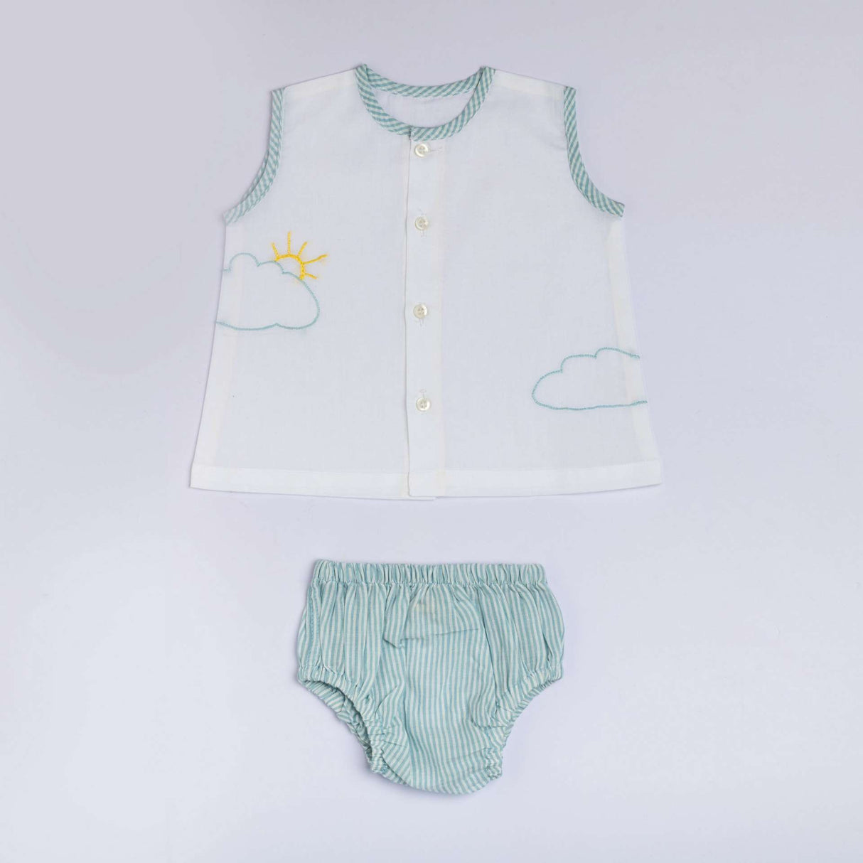 Flatlay of front open jabla with blue piping and hand embroidered clouds and sun with matched striped bloomers
