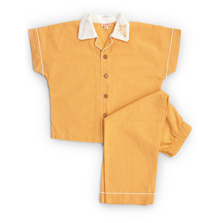 Flatlay of orange nightwear set with open collar shirt with hand embroidered collar and pants with elasticated waist