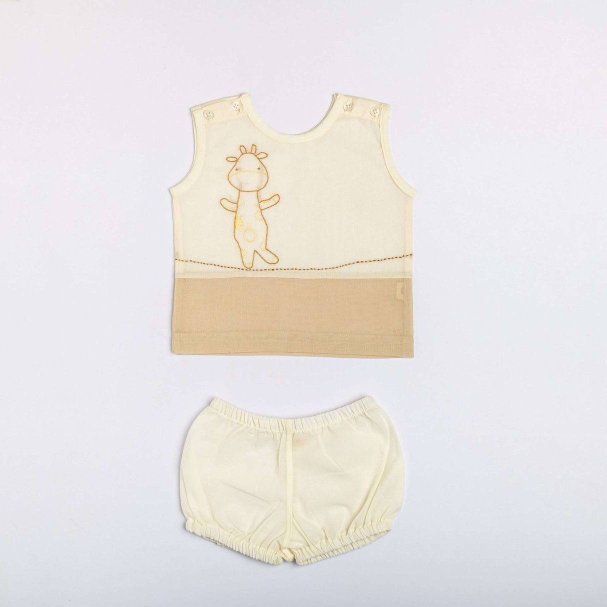 Flatlay of tan dual-tone hand embroidered baby vest and diaper cover set
