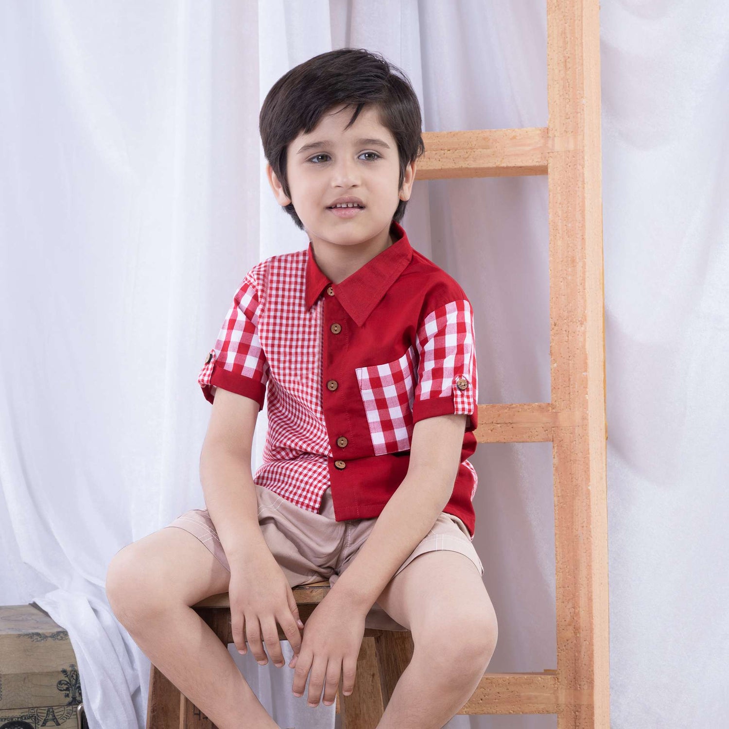 A boy dressed in a smart big and micro red gingham and solid red voile patchwork shirt