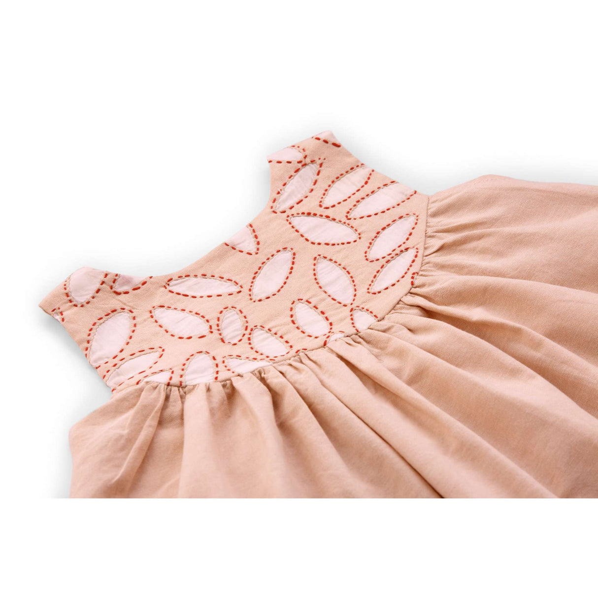 Flatlay of theclose-up of peach applique cotton dress with a hi lo hem with hand embroidered kantha edging
