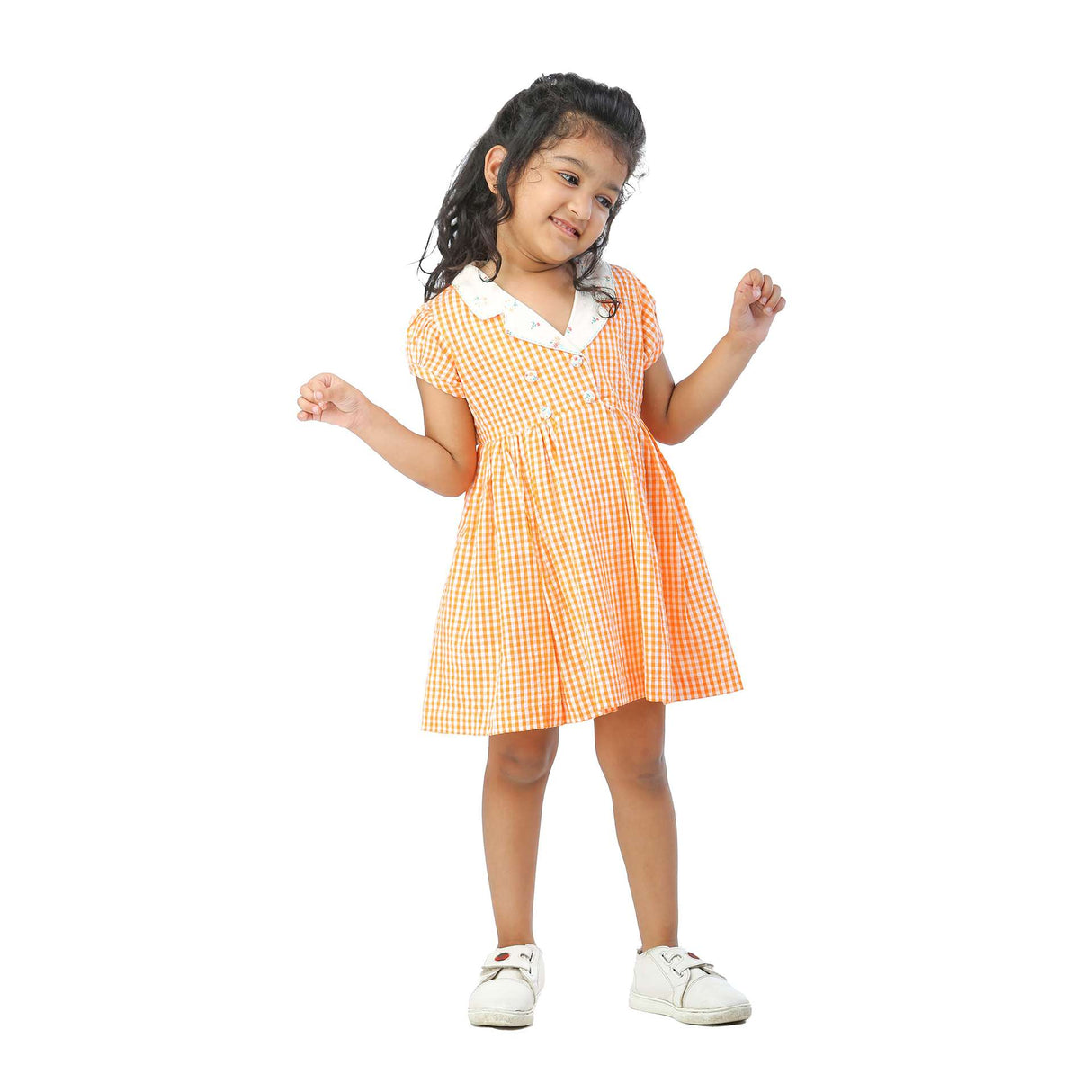 Little girl in orange gingham dress with faux-lapel closure, puff sleeves and hand embroidered Kantha-work
