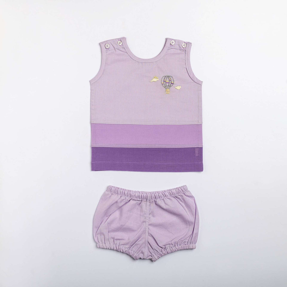 Flatlay of dual tone baby vest with french seams, and hand embroidery on vest paired with matching diaper cover