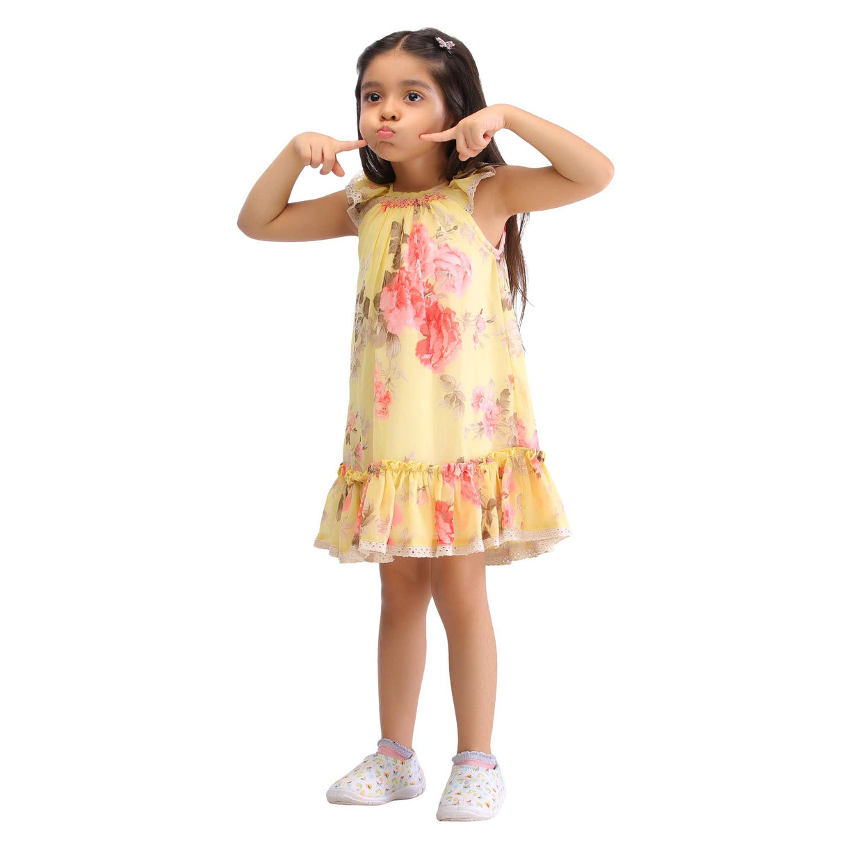 A little girl in yellow floral printed chiffon dress with hand smocked neckline