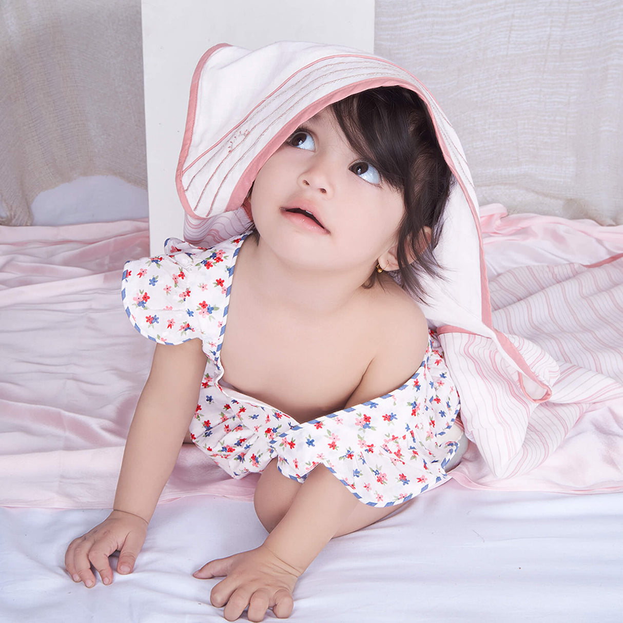 Baby girl crawls out of a hooded baby blanket