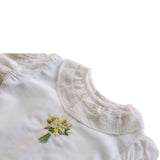 Lace neckline and intricate embroidered posy of flowers in this girls blouse