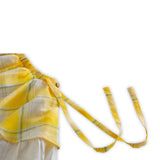 Girls skirt close up picture withside waist ties and a wood button