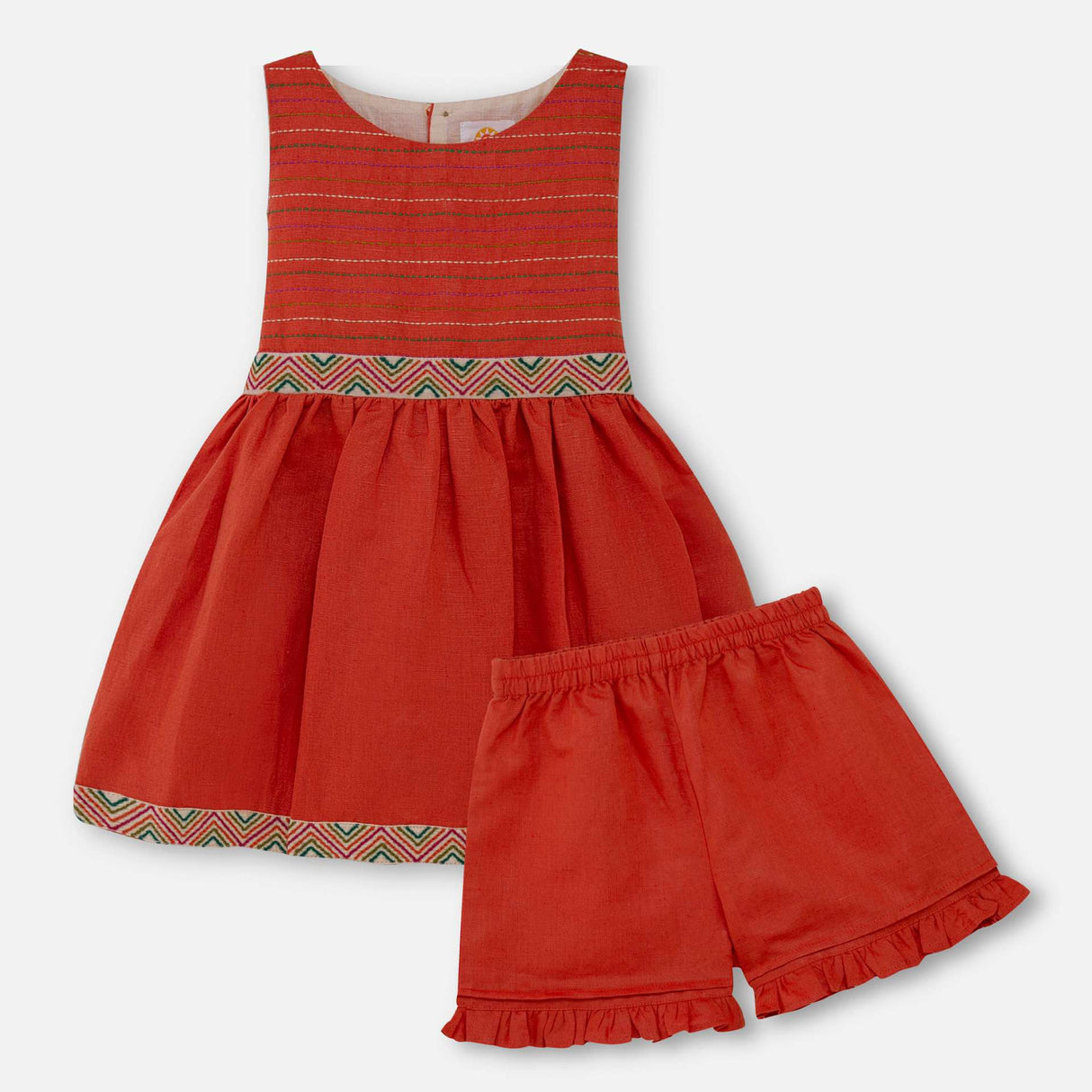 Flatlay of burnt-orange linen dress set with colourful embroidered waistline with a Kantha-work hand-embroidered bodice