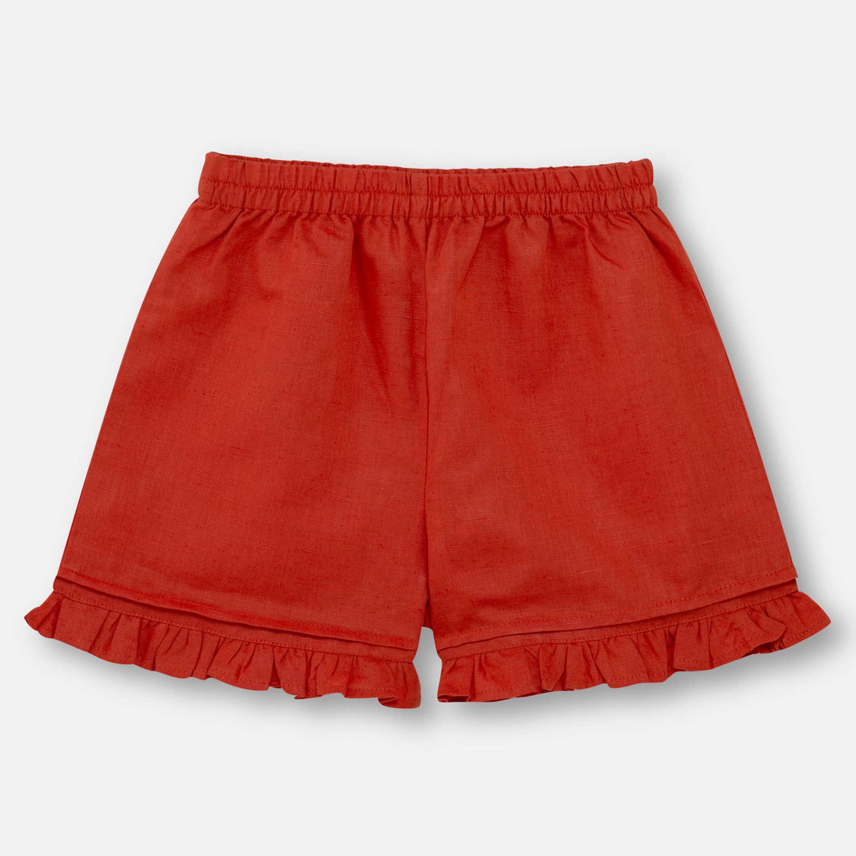 Flatlay of burnt-orange linen shorts that are paired with matching dress with colourful embroidered details