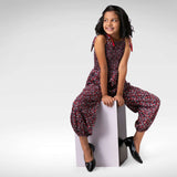 A jolly girl in floral printed jumpsuit with a shirred elasticated yoke, shoulder-ties, and cinched cuffs at the ankle