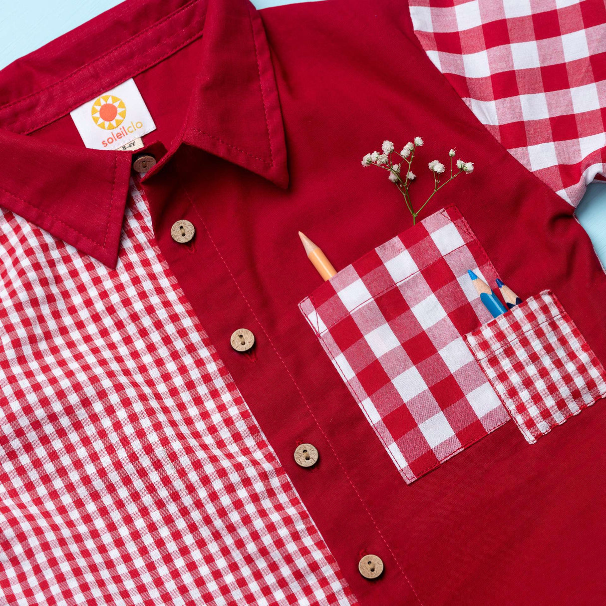 Flatlay of red checked shirt made from a patchwork of big and micro red gingham and solid red voile