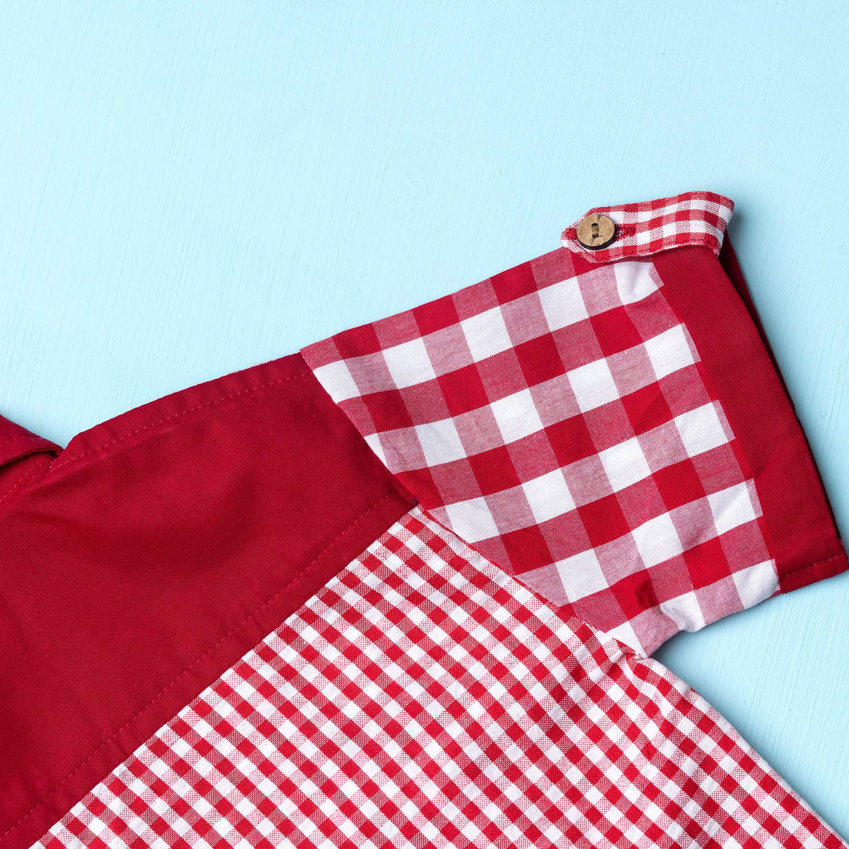 Close-up of red checks shirt made from a patchwork of big and micro red gingham and solid red voile