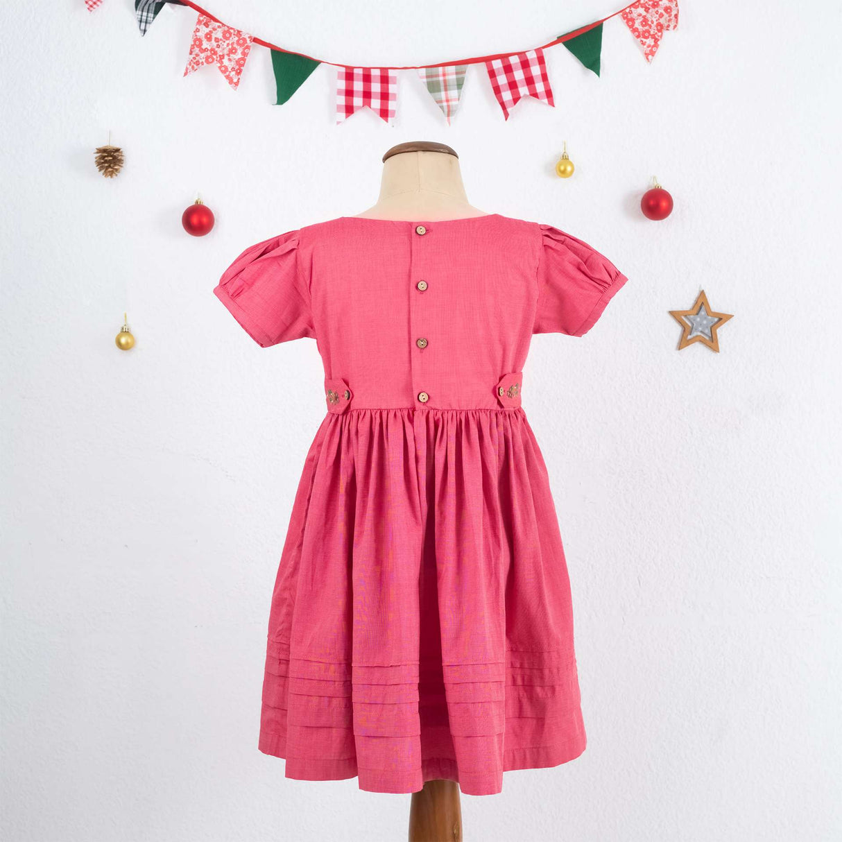 Rear mannequin shot of pink cotton dress with rear buttons and back tabs