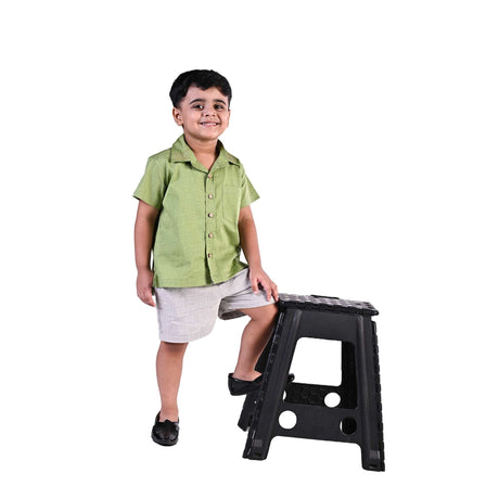 A little boy in green shirt with wood buttons and kantha hand embroidery on collar