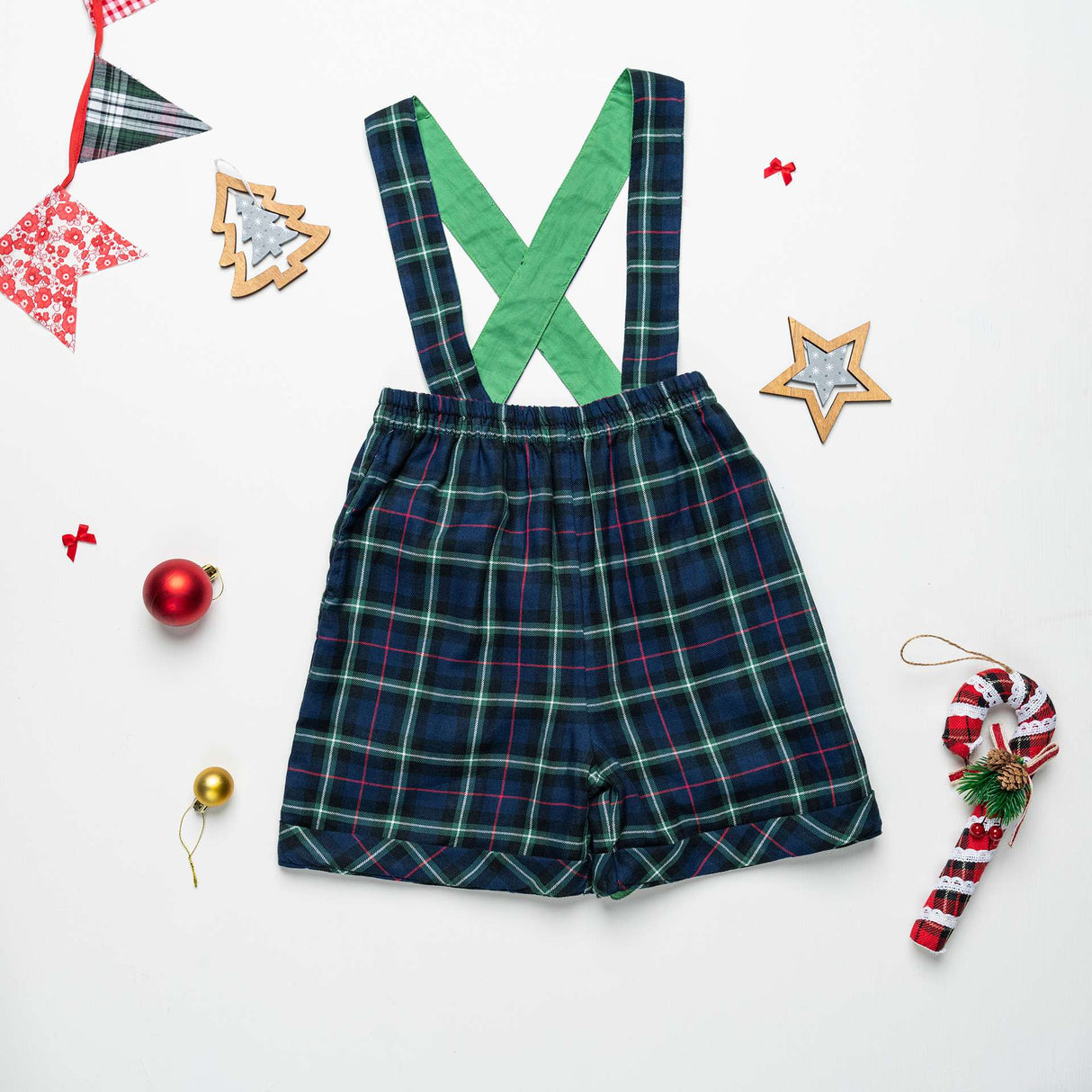 USuspender shorts in navy plaid with Christmas decorations strewn around