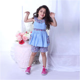 A girl in blue double gauze cotton tunic with floral ruffled neckline and tie-up belt paired with matching floral shorts