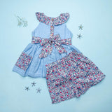 Flatlay of blue double gauze cotton tunic with floral ruffles and tie-up belt paired with matching floral shorts