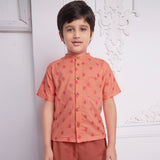 front view of boy wearing a orange geometric print shirt