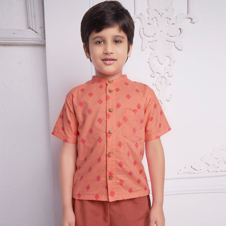 front view of boy wearing a orange geometric print shirt