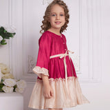 Side view of a girl posing in pink and ivory chanderi dress with front pearl buttons and a tie-up sash