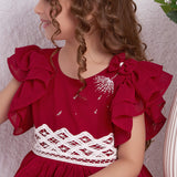 Close up of a girl in a red chiffon battenburg lace dress with pleated skirt