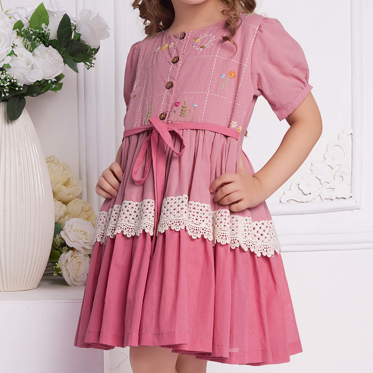 Close up of pink ombre embroidered dress with lace detail