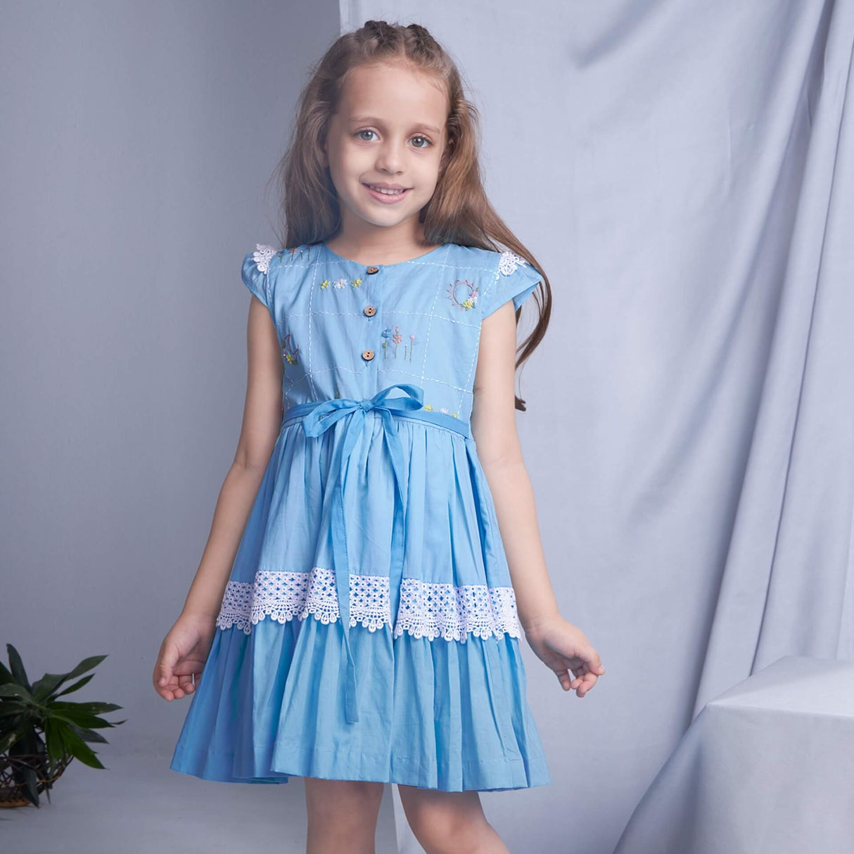 A girl posing in blue ombre embroidered dress with lace embellishment