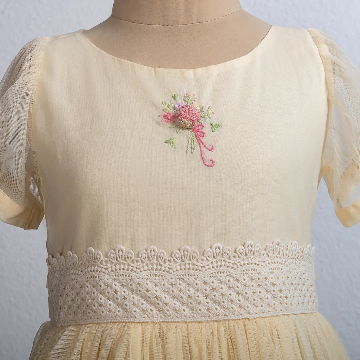"Close-up of a bouquet hand-embroidered on a yellow tulle dress."