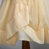 "Close-up of the can-can fabric attached to the yellow tulle skirt of the dress."