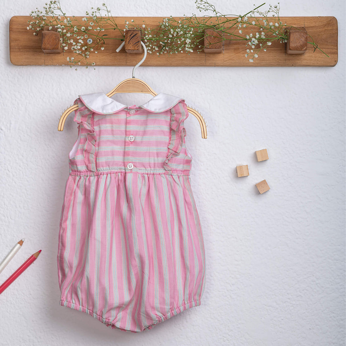 Back view of pink striped peter pan collared baby girl onesie fastened with buttons from Soleilclo.
