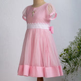 "Side view of a mannequin in a pink hand-embroidered tulle dress."