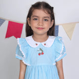 Close-up of the embroidery details on the blue cotton puffed sleeves dress.