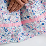 Close-up of a white floral printed strappy dress.