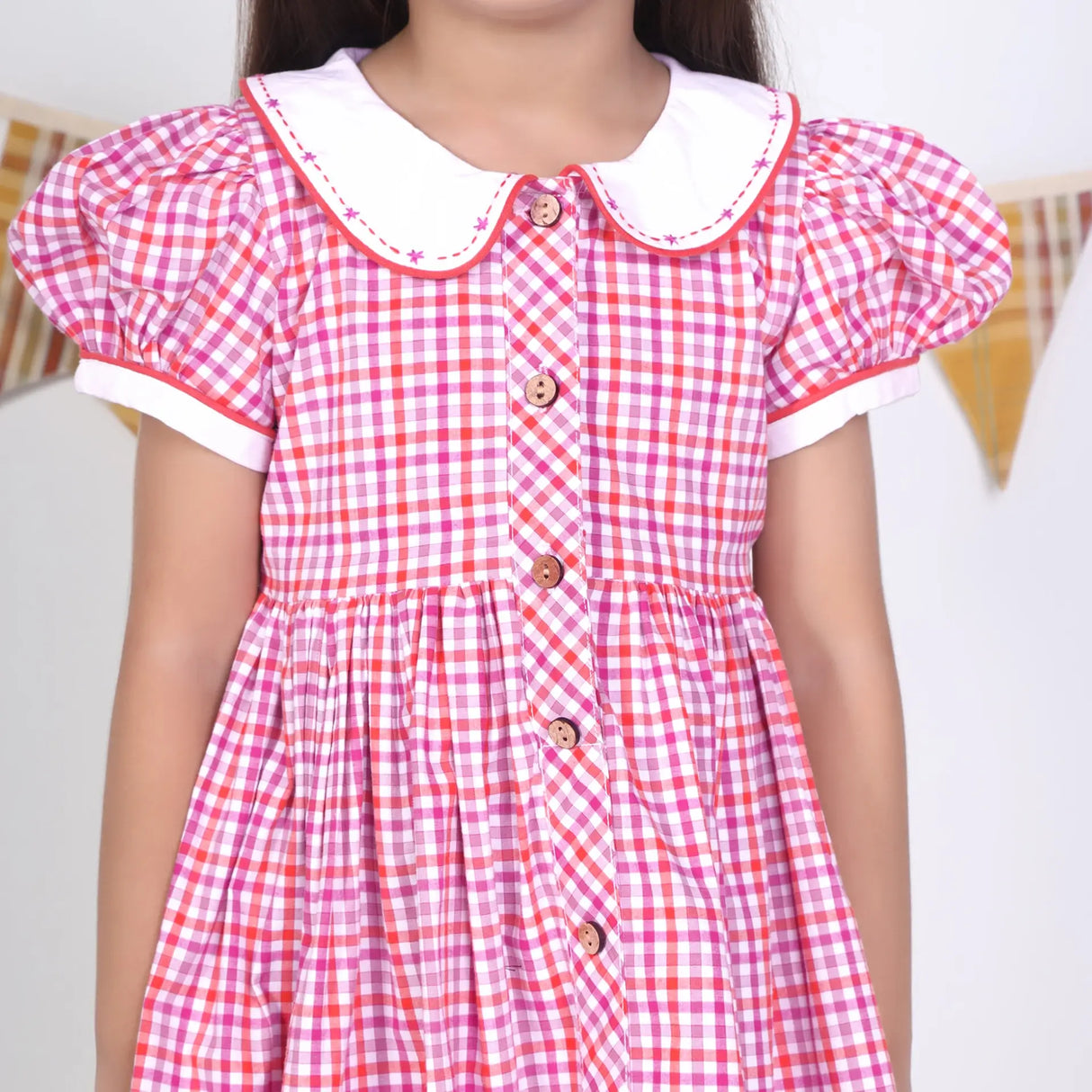 Close-up of the pink checked embroidered cotton puffed sleeves dress.