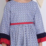"Close-up of a girl dressed in a navy floral printed cotton long ruffled sleeves dress."