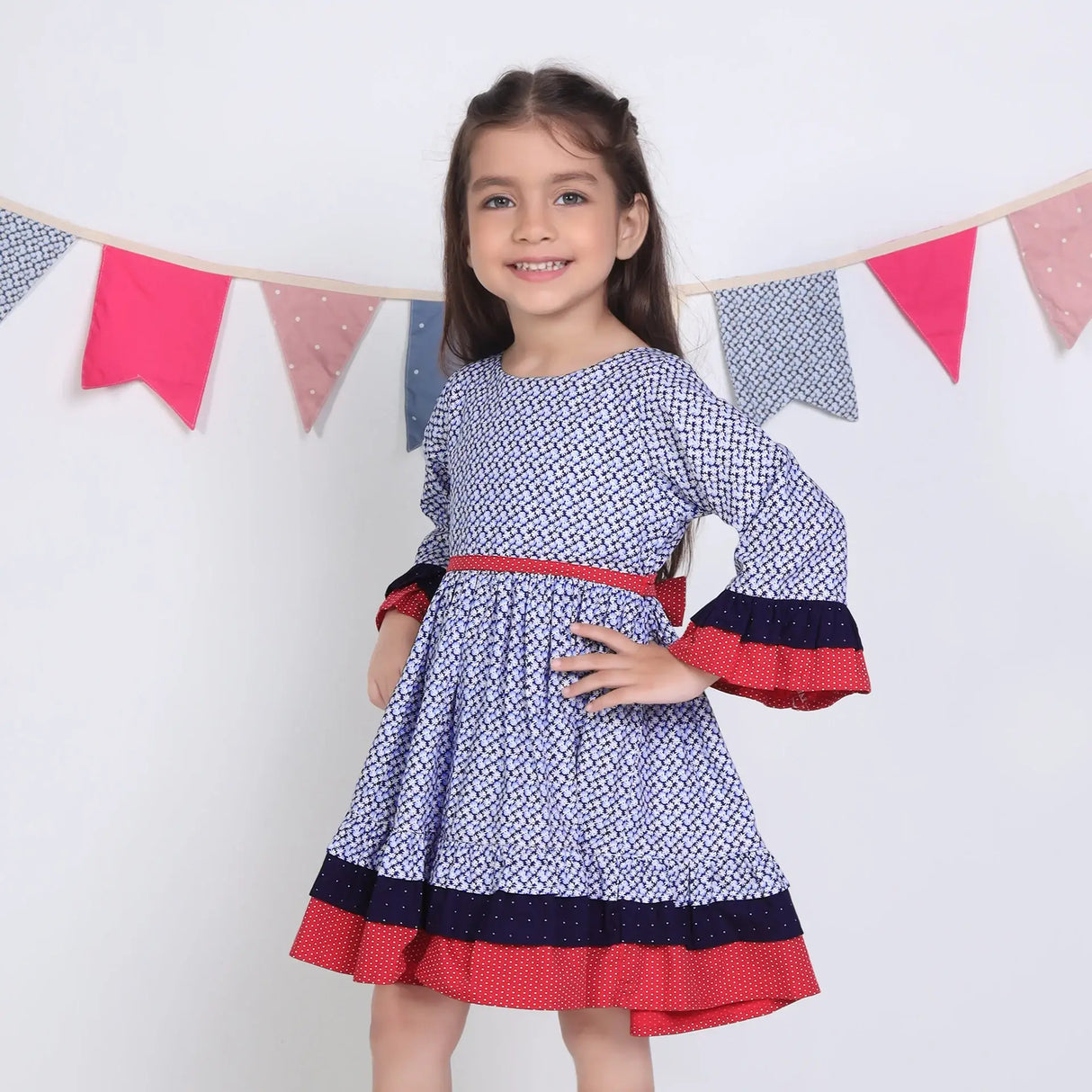 "Side pose of a girl in a navy floral printed cotton long ruffled sleeves dress."