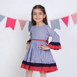"Side pose of a girl in a navy floral printed cotton long ruffled sleeves dress."