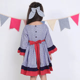 "Back pose of a girl in a navy floral printed cotton long ruffled sleeves dress."