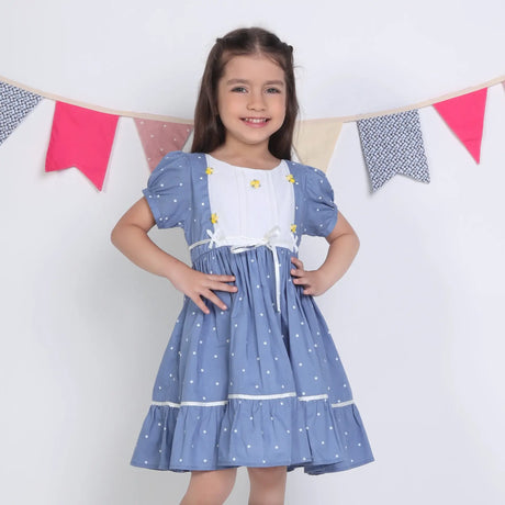 "A little girl posing in a blue embroidered cotton dot printed dress."