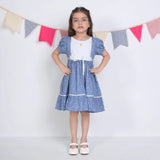 "A girl dressed in a blue embroidered cotton dot printed dress."