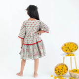 Back view of a girl dressed in a blue and red printed long sleeves cotton dress.