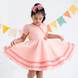 "A little girl twirling in a pink crossover chanderi puffed sleeves dress."
