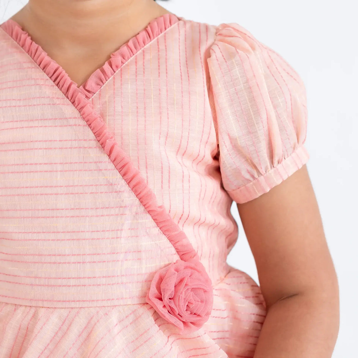 "Close-up of the crossover neckline and tulle rose on the pink crossover chanderi puffed sleeves dress."