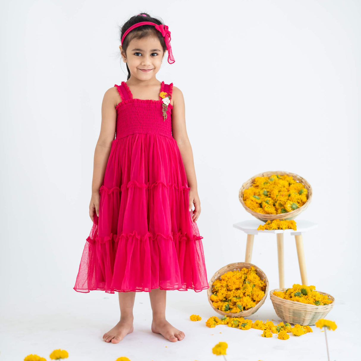 Girl dressed in a pink hand-embroidered crochet nylon tulle sleeveless dress.