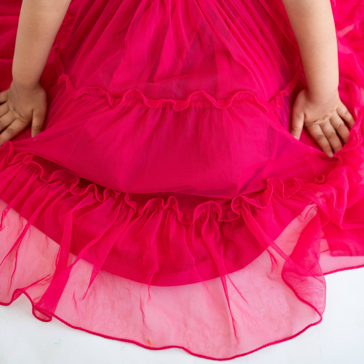 Close-up of the ruffles in a pink hand-embroidered crochet nylon tulle sleeveless dress.