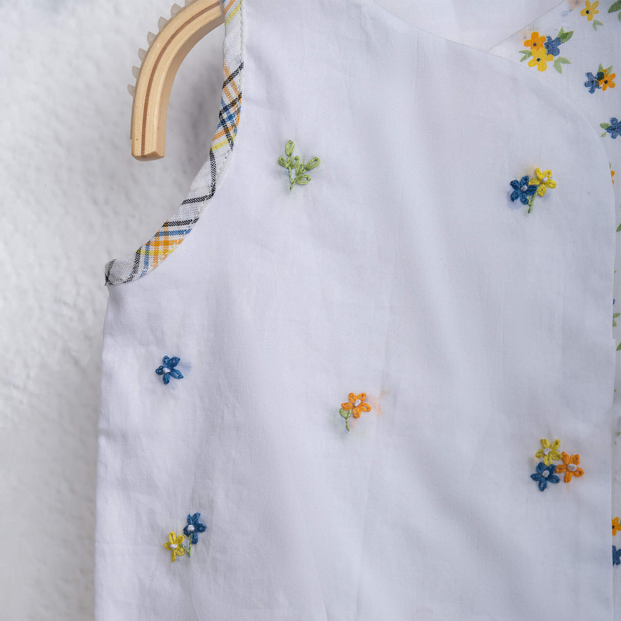 Closeup picture of hand-embroidered white jabla set for baby girl by Soleilclo.